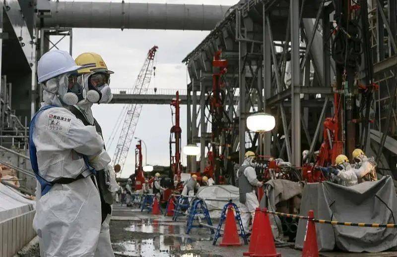 2014年7月，东电员工在福岛第一核电站附近施工 图片:CFP
