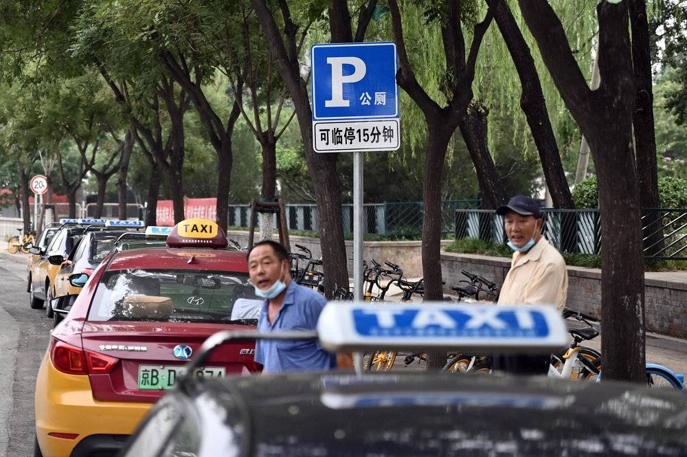 2020年8月5日，北京，两名出租车司机准备驾车驶离定慧桥旁的一处公厕临时停车区。 