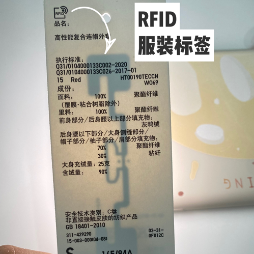 印有RFID标志的服装标签，透过光可以看到内部电路丨作者供图<br>