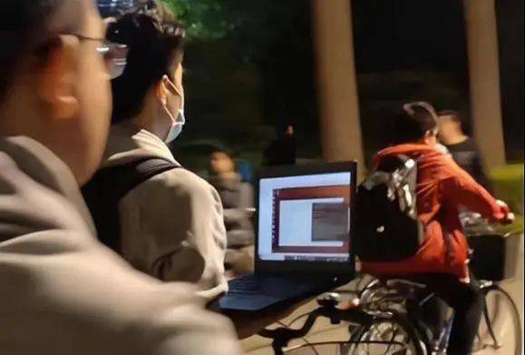 网传一名清华学生边骑自行车边用电脑跑程序，“内卷”由此出圈。图片：网络