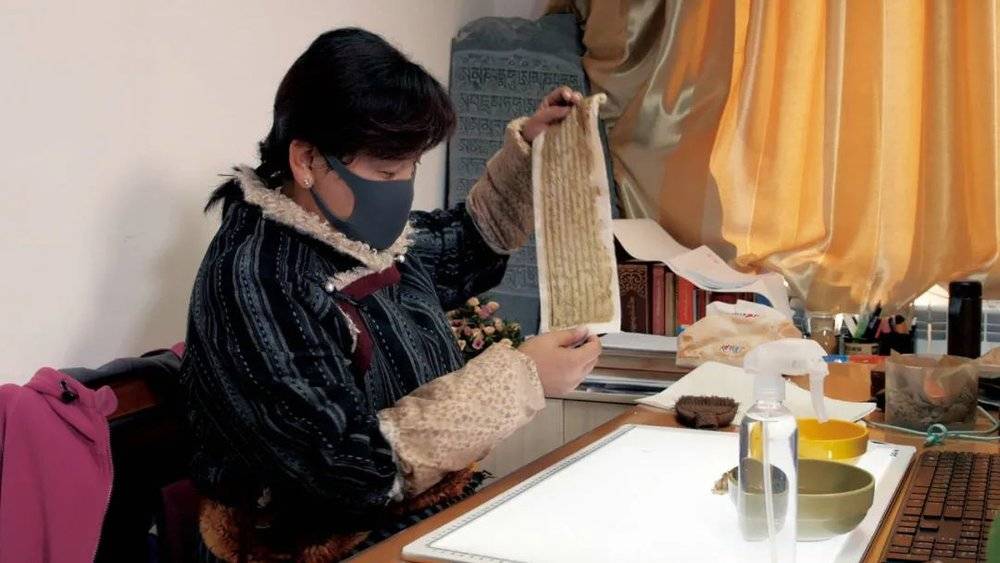 西藏自治区图书馆的古籍修复师央拉正在修复藏文古籍。<br label=图片备注 class=text-img-note>