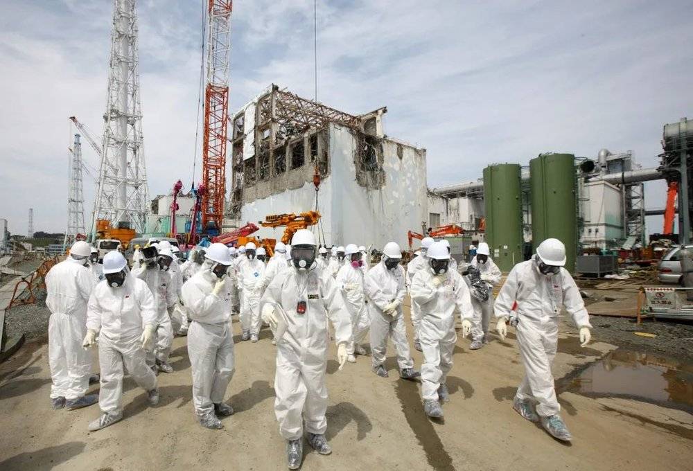 一群东电工人身穿防护服，准备进入受损的四号反应堆进行抢修工作 | www.nbcnews.com<br>