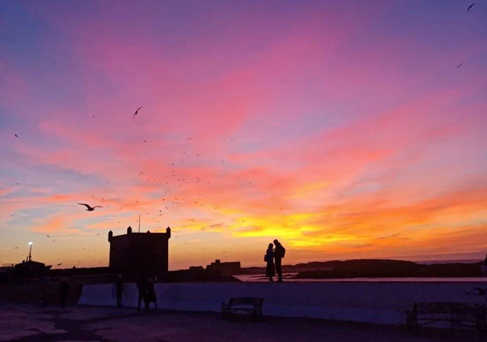 在索拉维看夕阳，张凯恰巧拍到了这样一幕，走上前去将图片传给了这对恋人，点燃了一整天的好心情。受访者供图。<br>