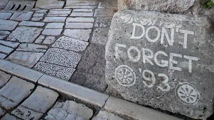 1993年，萨拉热窝“连续十七个月成为靶场”，到现在，街道旁立有这样一块石头，上面写着“不忘1993”。<br label=图片备注 class=text-img-note>