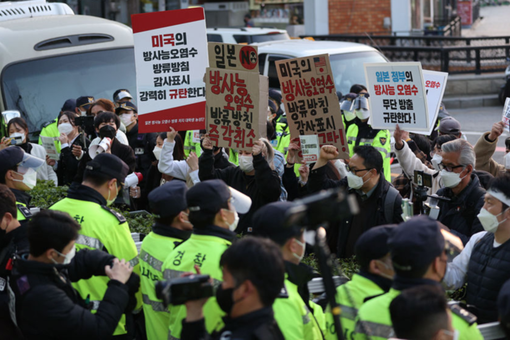 韩国民众手举标语在日本驻韩大使馆举行抗议活动，韩国警察在抗议现场维持秩序 / 人民视觉<br>