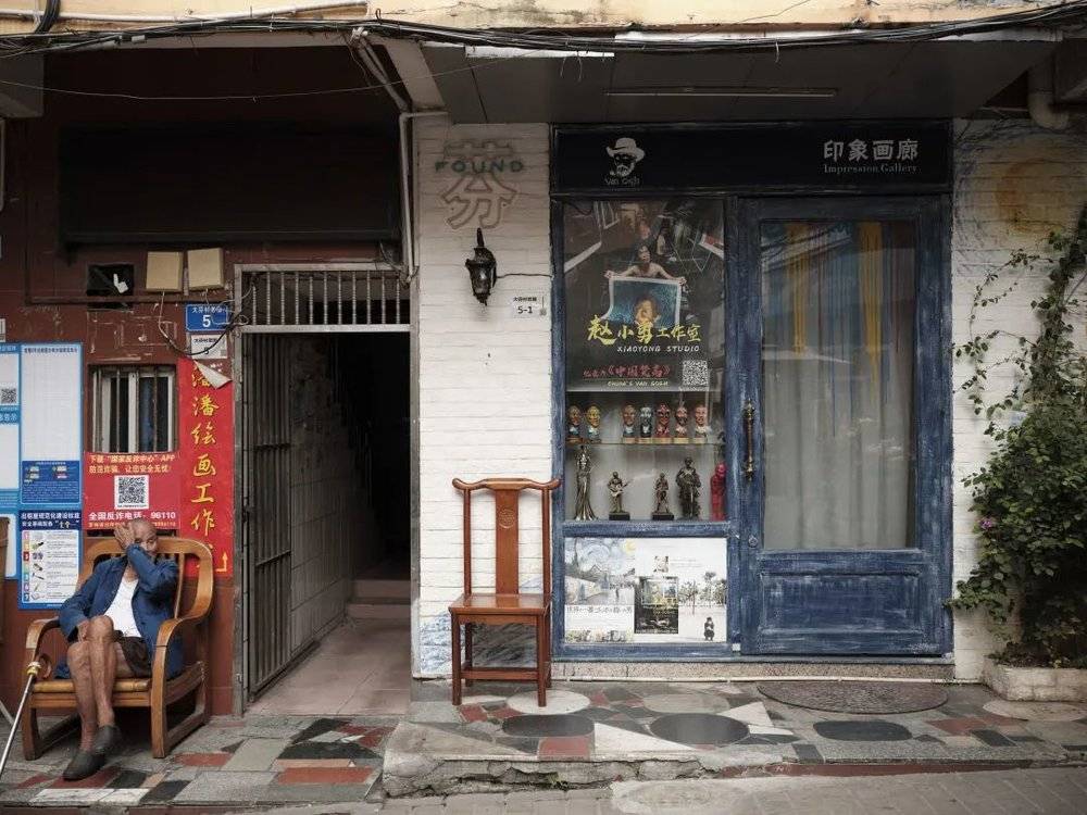 ⚪️ 大芬村画师赵小勇的工作室门口，他因纪录片《中国梵高》为人所熟知，24年间创作了逾10万幅梵高画作。