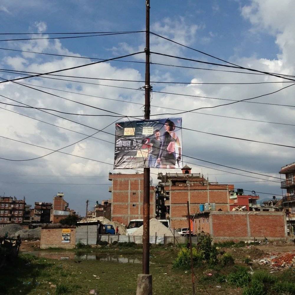 尼泊尔乡村一角，电线杆上悬挂电影海报。/ 家明<br>