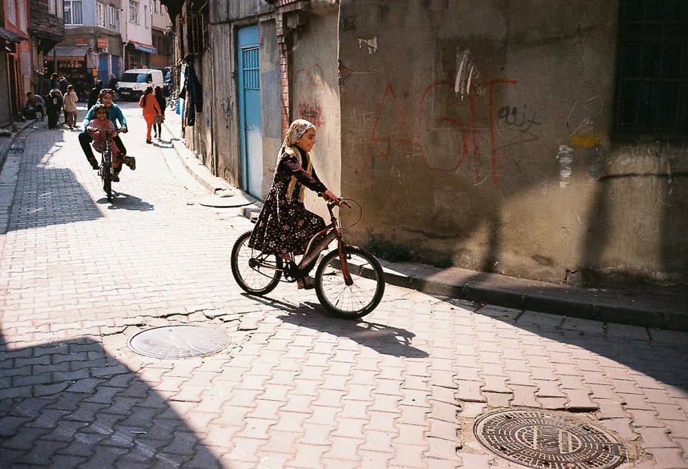 法提赫区，从坡道上骑自行车俯冲而下的库尔德少女。<br>
