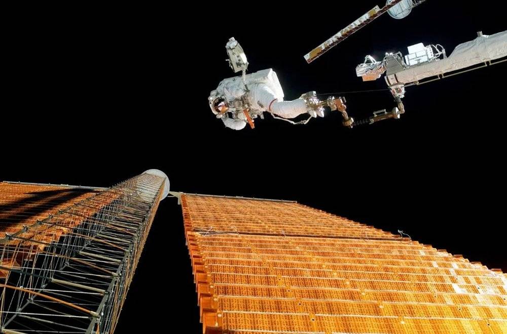 NASA宇航员对国际空间站的一个太阳能电池阵列进行维护。图/IC<br>