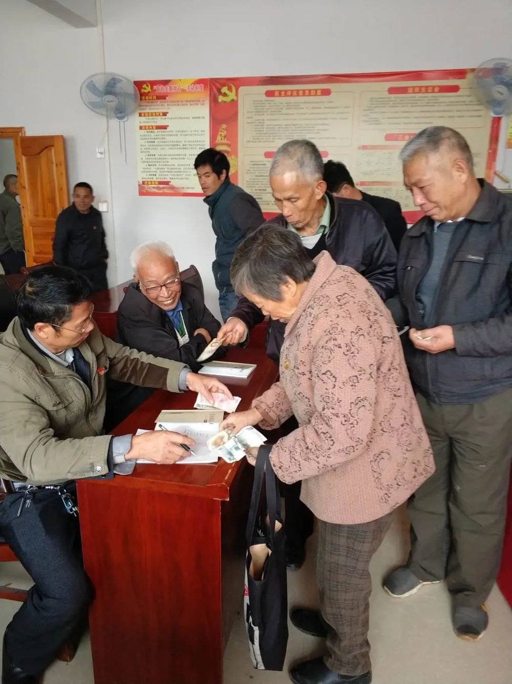 2017年11月24日，公保村村委会。党员大会后，老党员们纷纷主动缴纳党费。<br>