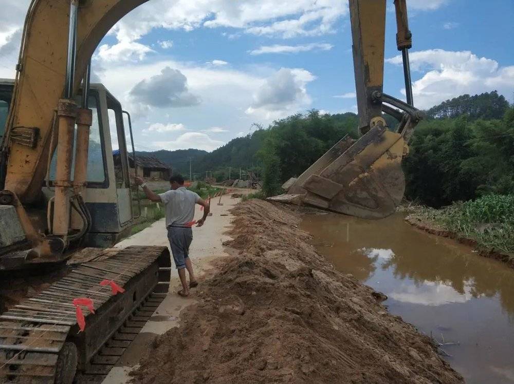 2018年05月29日，公保村。由于连日暴雨，公保村一条通组道路被河水“掏空”路基，村民小组长主动用自家挖掘机就地取沙填埋，修复路基，确保村民出行安全。<br>