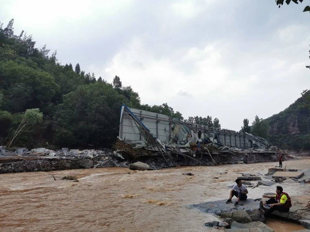 在下游做备份的两名队员和当地村民。对岸的石材加工厂在暴雨中完全冲毁了。