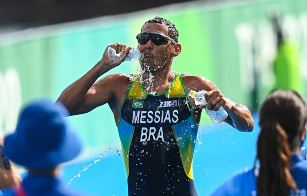 参加男子铁人三项的巴西运动员在比赛中抓紧时间快速补水。（图源：雅虎体育）