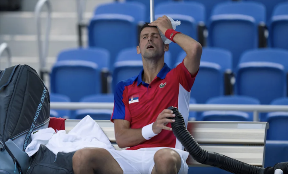 塞尔维亚网球明星德约科维奇一手用冰袋敷着脑门，一手吸着制冷后的空气。（图源：新华社）