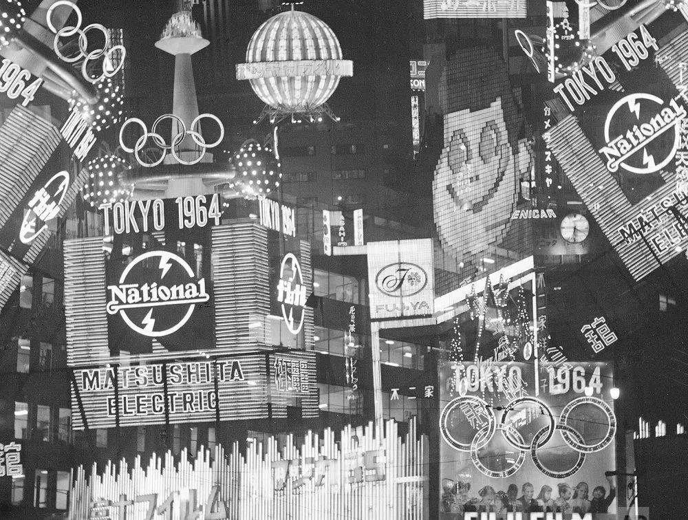 1963年的东京市中心，闪烁的霓虹灯和东京奥运会的标志交相辉映。<br label=图片备注 class=text-img-note>