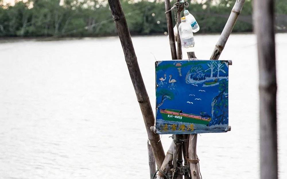 文昌八门湾，红树林边，挂着渔家港湾的招牌。<br>