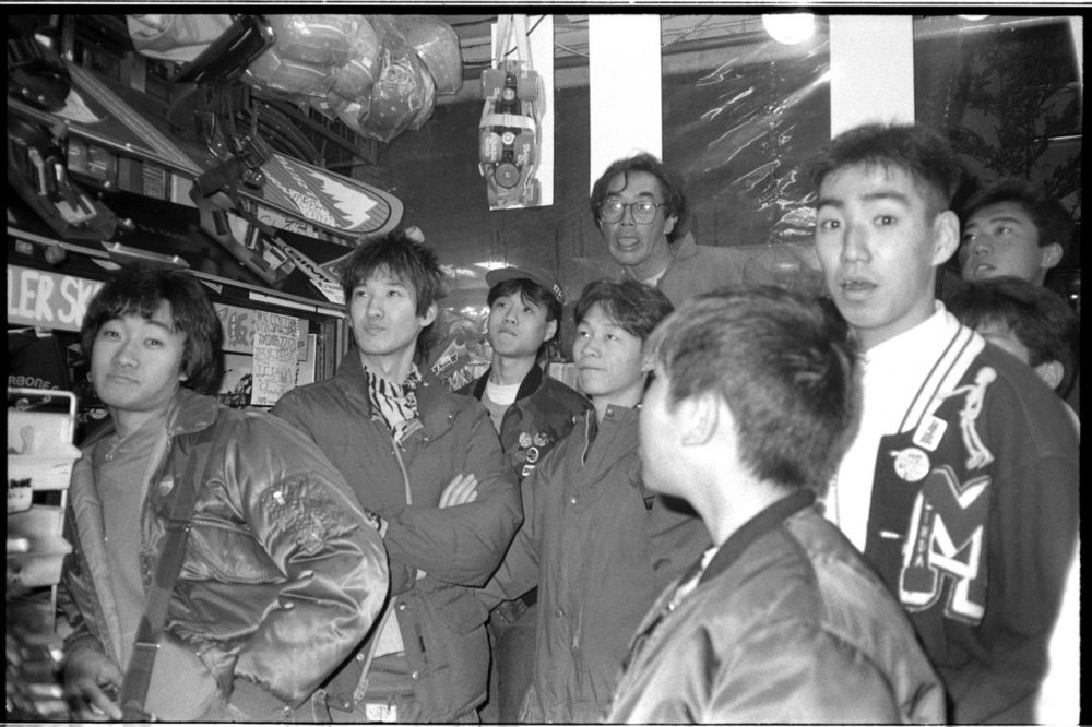 1984年一群日本板仔聚集到原宿的一家滑板商店观看刚刚到店的滑板录像带<br label=图片备注 class=text-img-note>