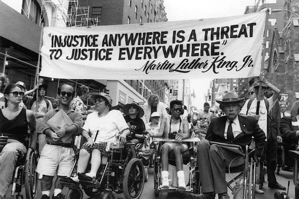 在呼吁大家关注残疾人法案的活动现场，人们引用了马丁·路德·金的话“任何地方的不公不义，都威胁着所有地方的公平正义。” | Tom Olin<br>