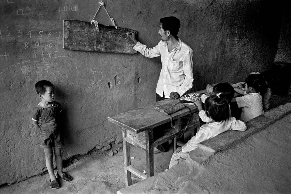 1991年9月，陕西省绥德县国子沟村教学点，这是一个最小的民办教学点，代课老师仍坚守“阵地”，一块简易木板充当教学黑板。摄影/解海龙