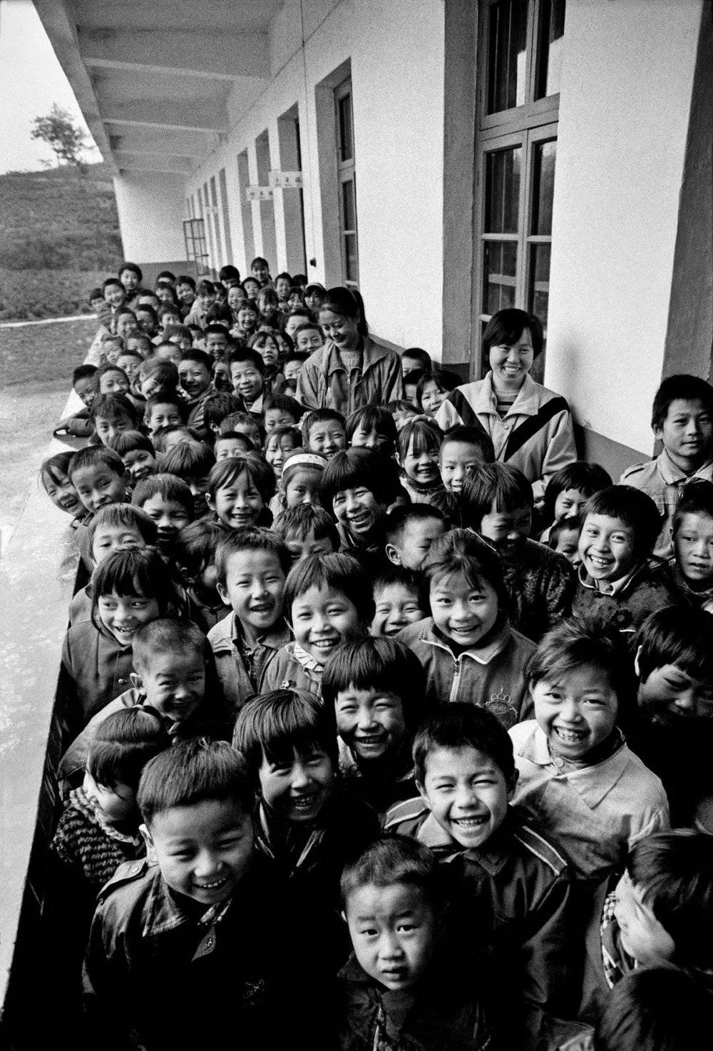 加拿大华人王华瑞老先生在报纸上见到红安县七里坪镇周七家小学的报道，捐资42万港元，建了一所现代化学校，十里八乡的孩子们都来此上学。1993年10月， 解海龙再次来到周七家小学，记录下师生们的开心一刻。摄影／解海龙
