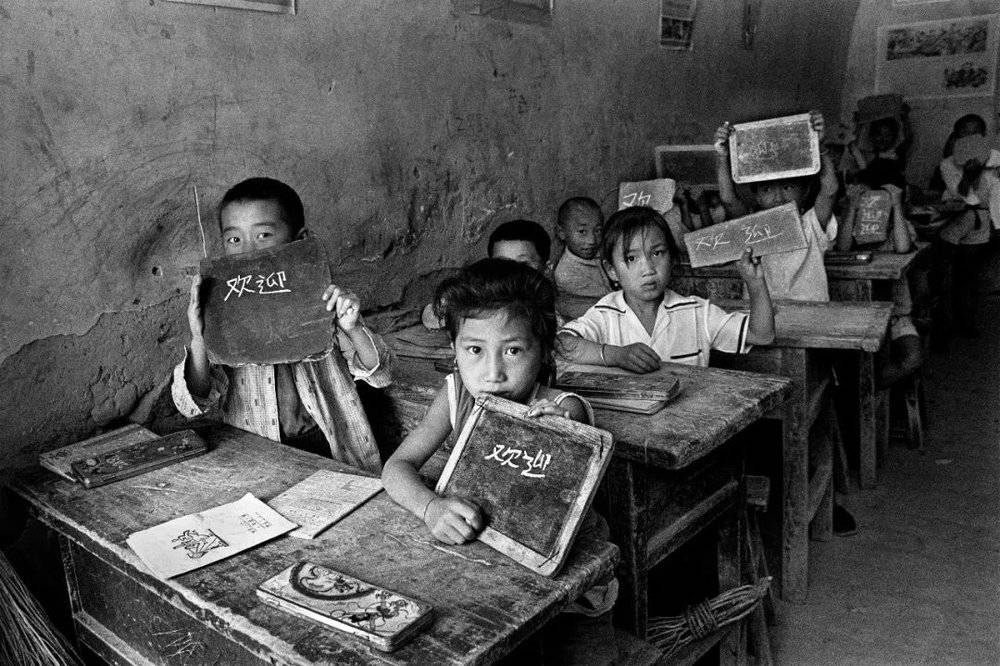 1991年9月，陕西省绥德县楼沟村小学的学生们在窑洞里上课，每人都有一块石板当写字本用。摄影/解海龙