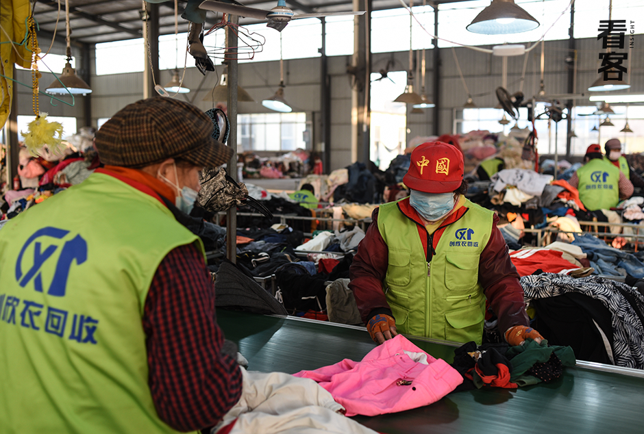 一位戴着印有“中国”字样帽子的女工在分拣衣物
