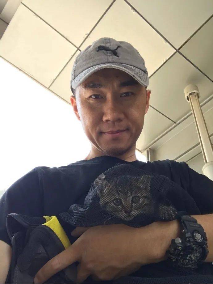 孙锦荣和一只被救助的小猫 图源：微博
