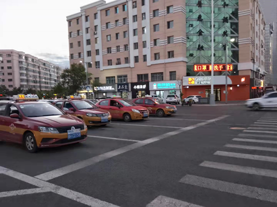 傍晚时分鹤岗街头，四辆出租并排通过，图源作者<br>