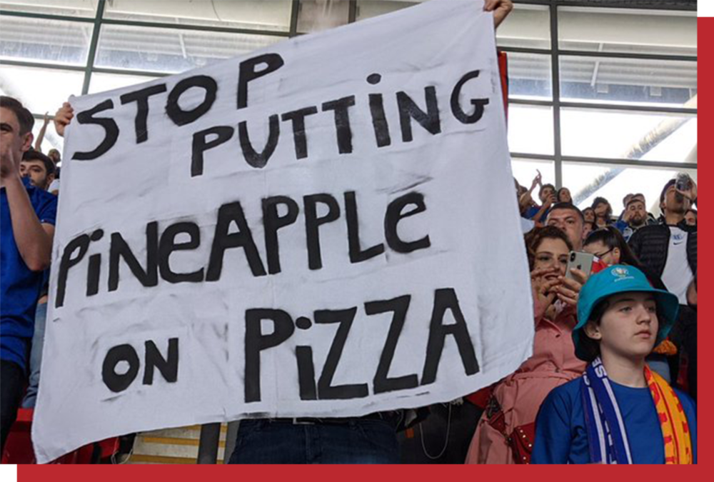 意大利球迷高举着“STOP PUTTING PINEAPPLE ON PIZZA（停止往比萨上放菠萝）”标语。© Twitter.com