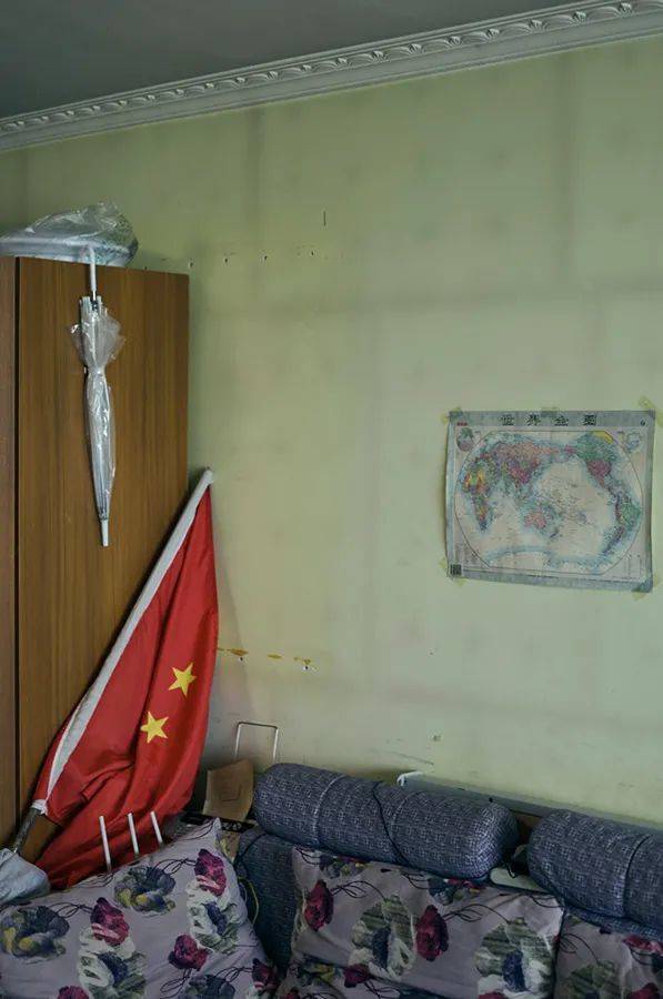 模特家里的墙上挂的是世界地图，左边是一张鲜艳的国旗   “北京公寓”系列作品 138×92cm 艺术微喷 2015-2021