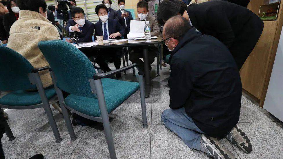 张德俊的父亲跪倒在地，请求调查儿子的死 图片：BBC<br label=图片备注 class=text-img-note>