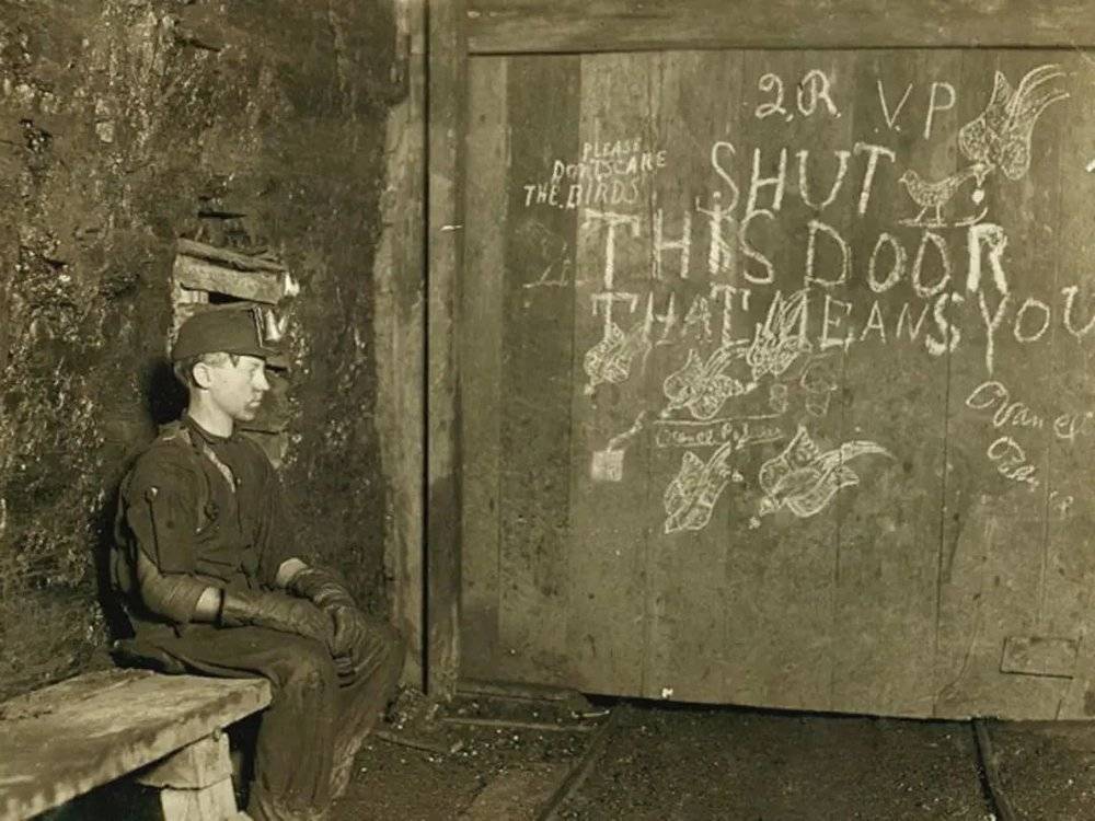 20世纪初期，负责在煤矿井下给矿车开门的童工，日复一日做着重复的劳动。（图源：美国国会图书馆）<br>