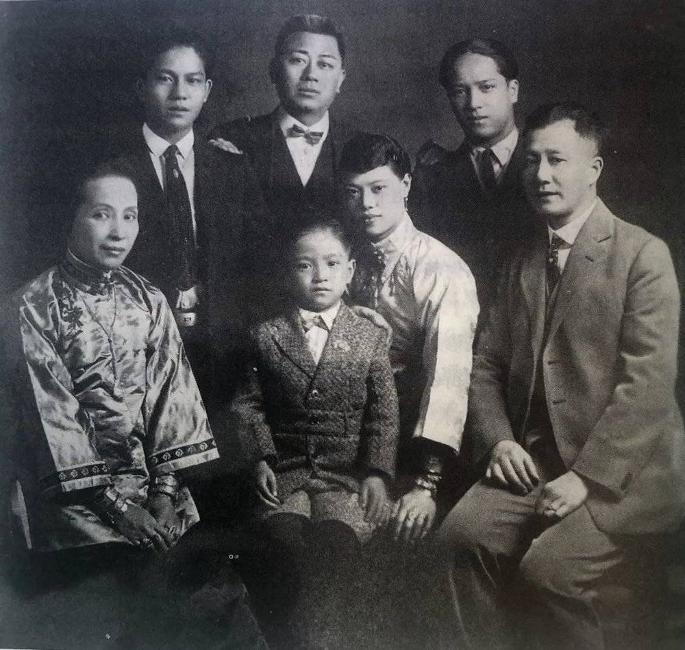 女伶关影怜与教母及其家人的照片，1940年代末，关坐在中间，有个小男孩坐在她腿上（小布鲁斯·关 提供）。<br>