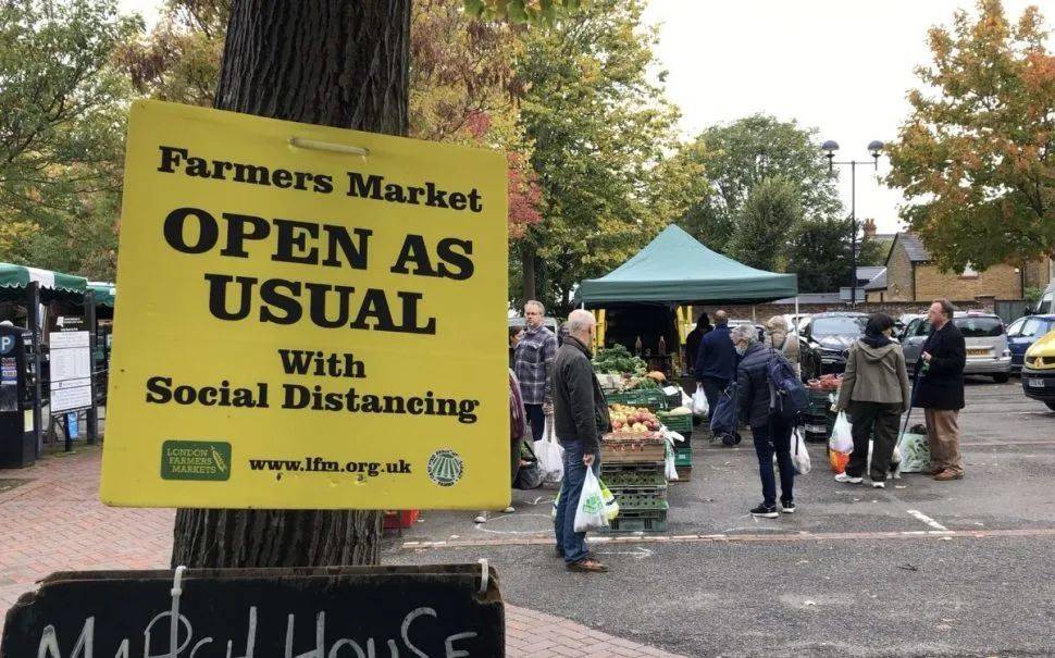 市集门口的告示上写着：农夫市集在保持社交距离的前提下照常开放。图：SWLondoner<br>