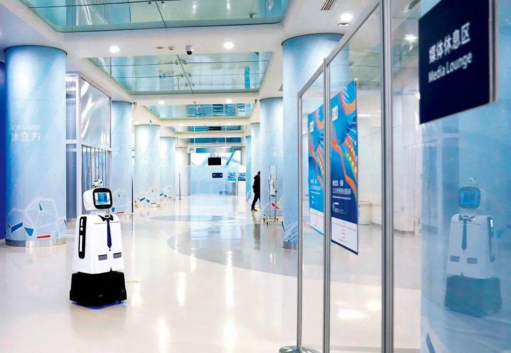 ▲ 2021年10月23日，5G智能机器人在“相约北京”2021世界轮椅冰壶锦标赛的场馆内巡逻，它可以完成测量体温、提示佩戴口罩、物品递送等工作 张晨霖摄<br label=图片备注 class=text-img-note>