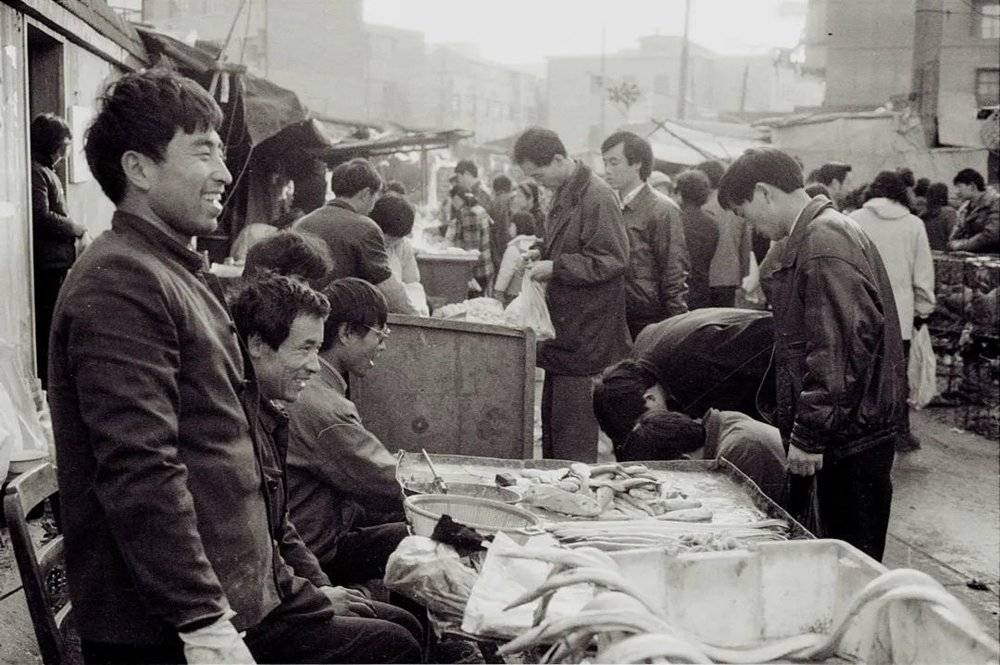 直到90年代，上海还有马路菜市场。图为1993年上海大木桥路附近的马路菜场。图：高尔强<br>