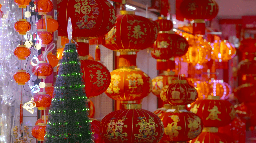 在义乌商贸城，圣诞树边就放着春节的大红灯笼，图源：纪录片《圣诞快乐，义乌》