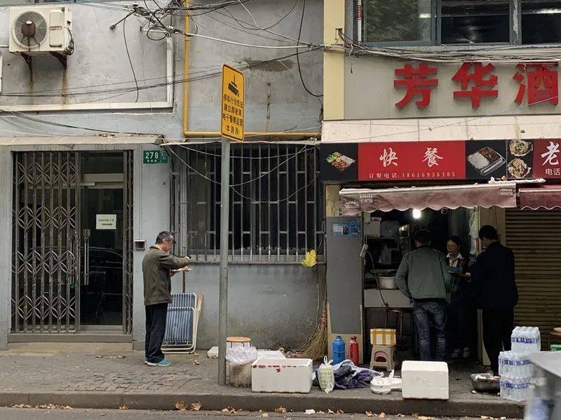 在这家盒饭店门口，有些人站着就把午饭吃了