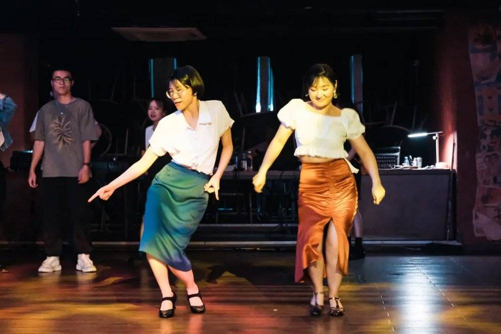 在 Mao livehouse 成都，静静（右）和跳摇摆舞认识的好友穿着颜色亮丽的摇摆舞裙
