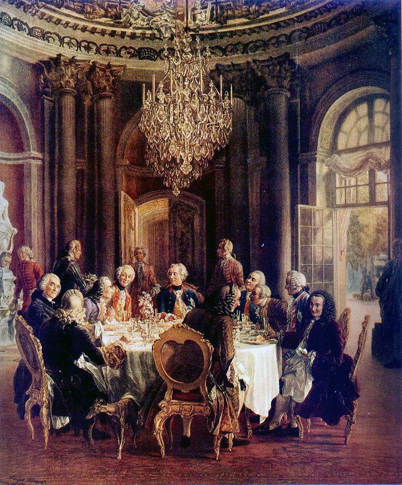 阿道夫·冯·门采尔所绘的《圆桌》（Die Tafelrunde）。腓特烈大帝的宾客齐聚在无忧宫的大理石大厅，其中包括伏尔泰（左起第三，坐者）/wiki<br>