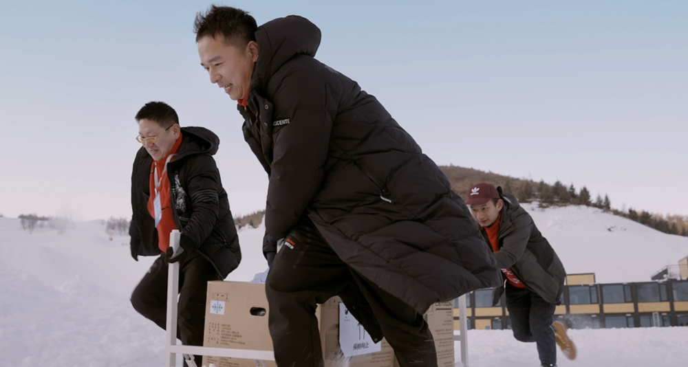 陈艳和同事一起在雪地里搬运设备。<br>