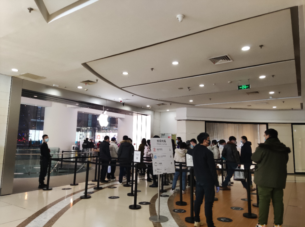 1月22日晚间，不少消费者在北京西单大悦城苹果体验店外排队等待
