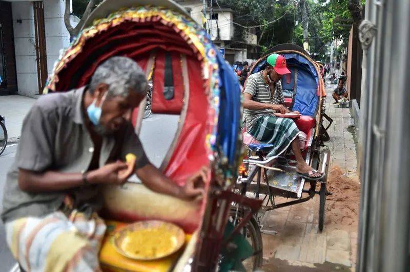 孟加拉国达卡，人力车司机正短暂停下吃饭。对南亚许多人来说，兼顾“地球健康”的餐食成本超出了他们的能力范围。来源：Munir Uz zaman/AFP/Getty<br>
