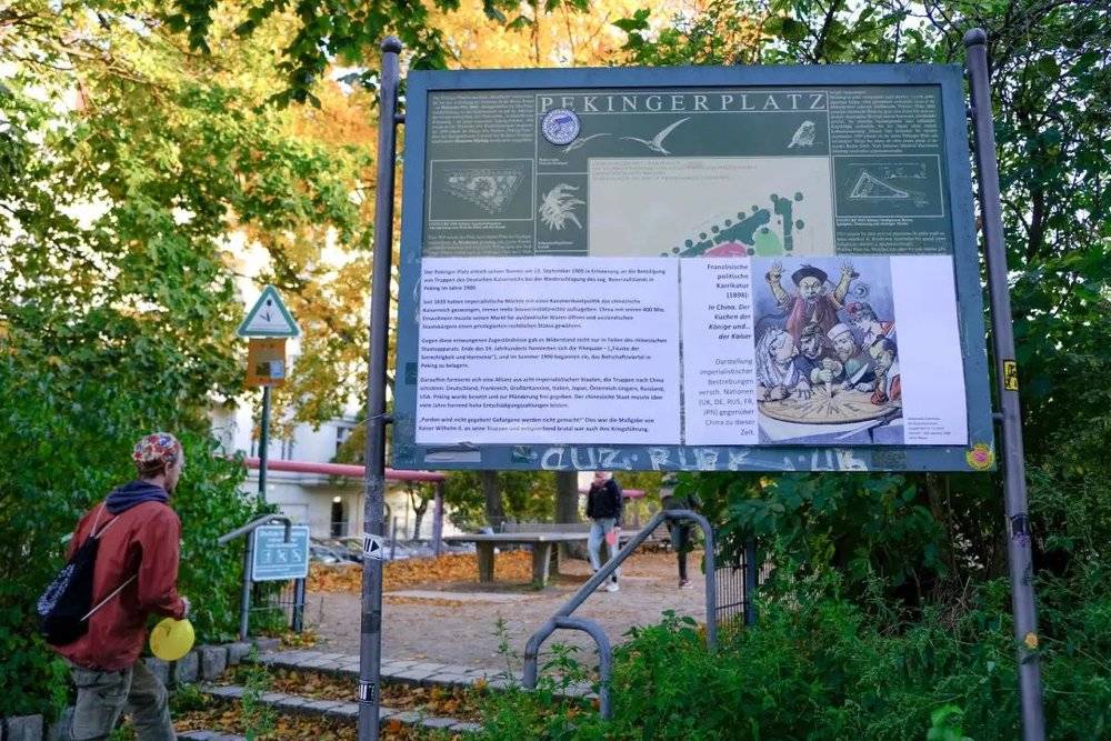 北京花园前的一个导览牌被志愿者们贴上了关于八国联军侵华的历史。图片来源：明晔<br>
