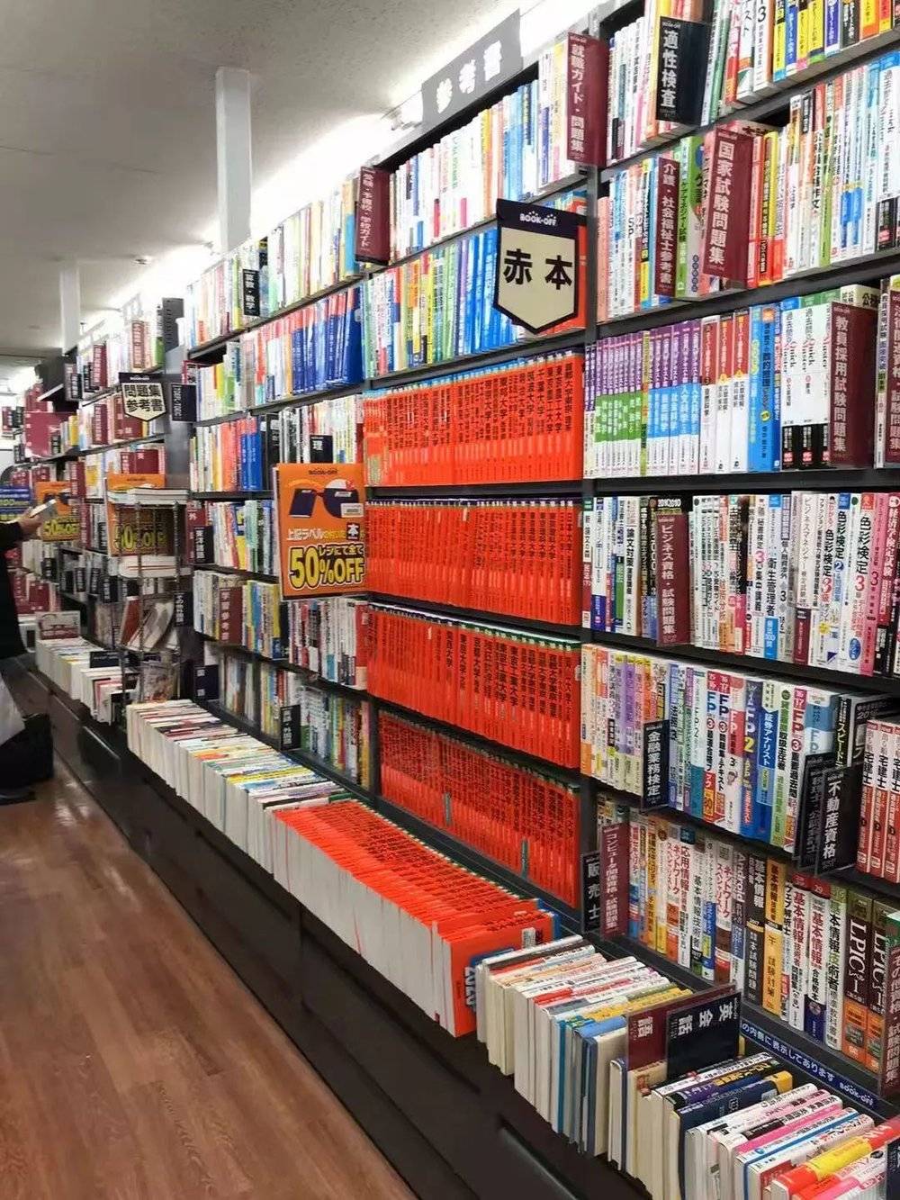 ▲日本书店，红色部分为名校过往试题集，摆满了一面书架<br>