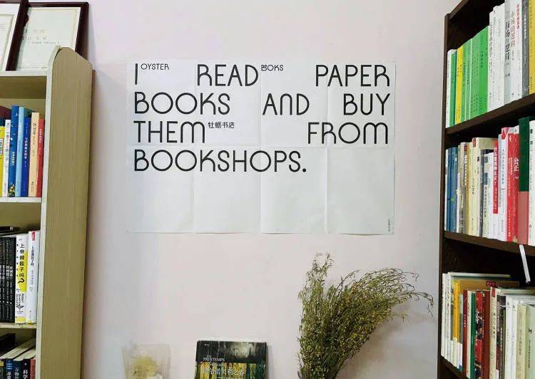 北京，参差书店。墙上贴着的标语意为：我读纸质书，并且从书店买书。/@参差书店微博<br>