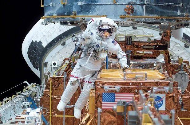 修复期间宇航员舱外工作 图片来自：NASA<br label=图片备注 class=text-img-note>