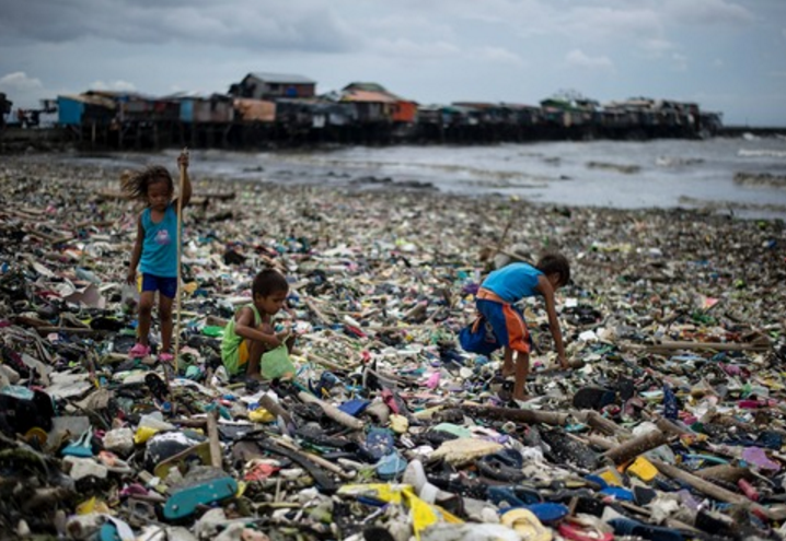 台风过后的菲律宾马尼拉湾岸边堆满了潮水带来的垃圾，孩子们在垃圾堆中收集塑料瓶<br label=图片备注 class=text-img-note>