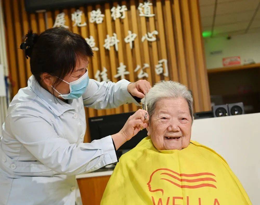 2021年12月10日，北京百万庄养老照料中心护理员冯爱芬为老人理发。这家“隐藏”在老旧小区内的养老机构服务着十多名老年人，工作人员中包括像冯爱芬这样荣获“最美家政人”（李贺/摄）