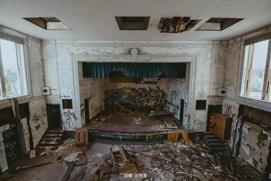 潘然拍摄的废墟，墙上有涂鸦，桌椅被摔毁。